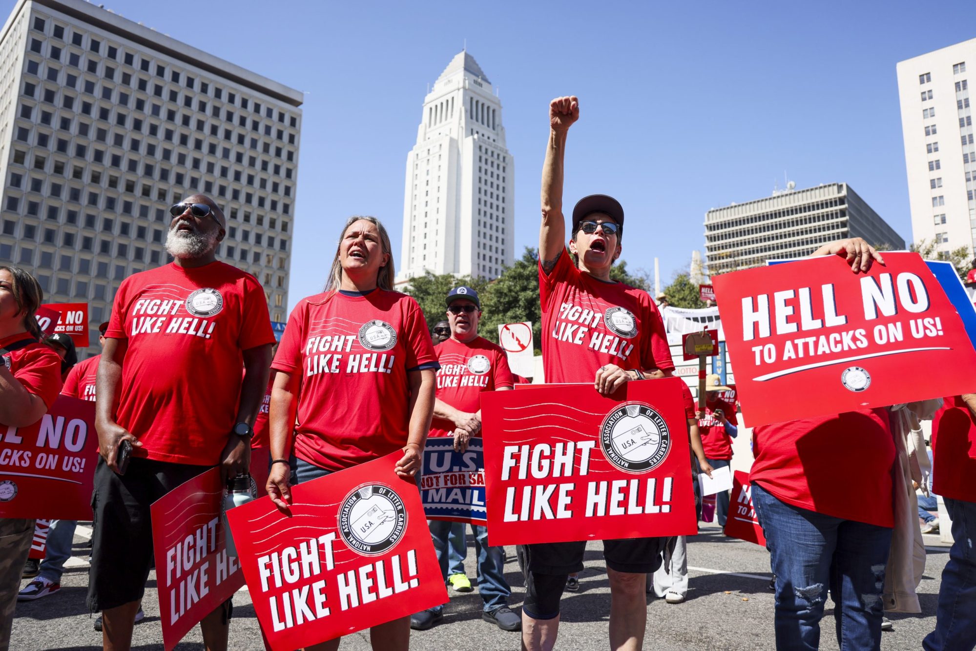 Los Angeles, CA - March 23: Postal workers Darrell Jefferies, Molly Berge, Shannon Canzoneri, and Maria Guerra rally at the Federal Building to protest the possible privatization of the USPS under the Trump administration on Sunday, March 23, 2025 in Los Angeles, CA. Juliana Yamada / Los Angeles Times via Getty Images